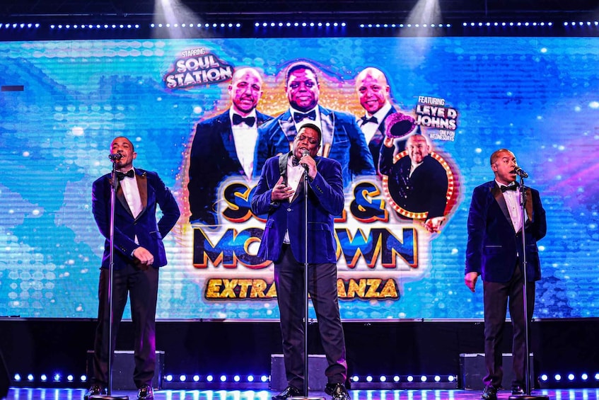 A stage with a large screen displaying 'Soul Station' and 'Extra Rumba' text, and performers in formal attire. 1