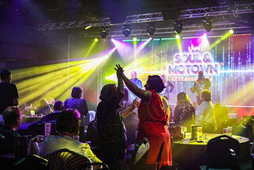 A concert with a stage displaying 'Soul & Motown Extravaganza' and a crowd of people. 4