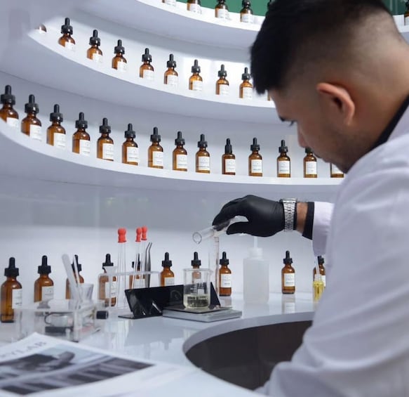 A person in a lab coat handling a test tube. 2