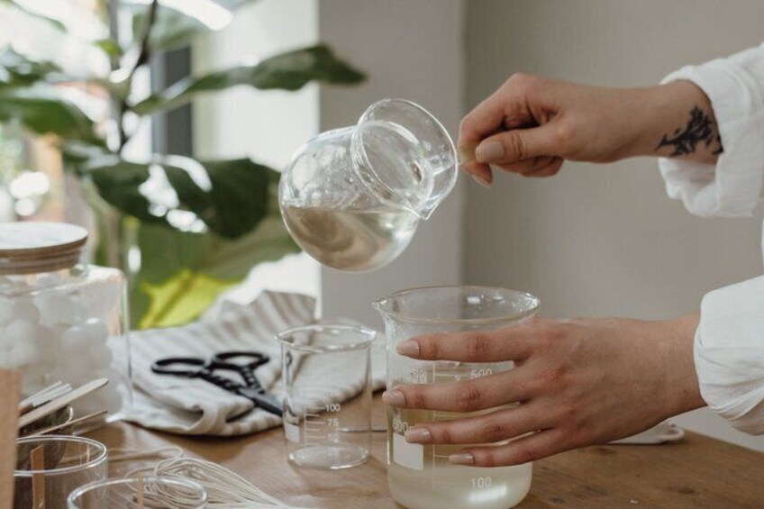 A person pouring a clear liquid into a measuring cup. 1