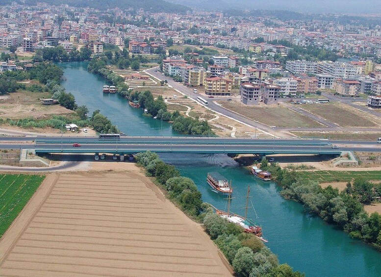 A river with boats, a bridge, and a cityscape with buildings. 3
