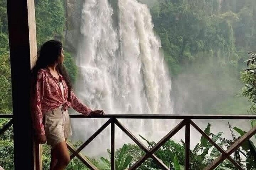 A person standing by a railing, overlooking a waterfall. 2