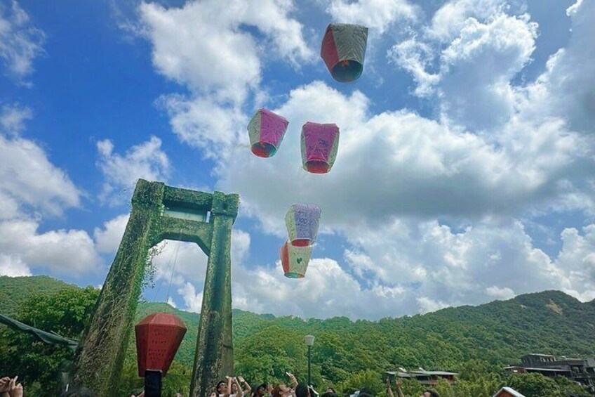 A traditional arch structure with lanterns flying above it. 3