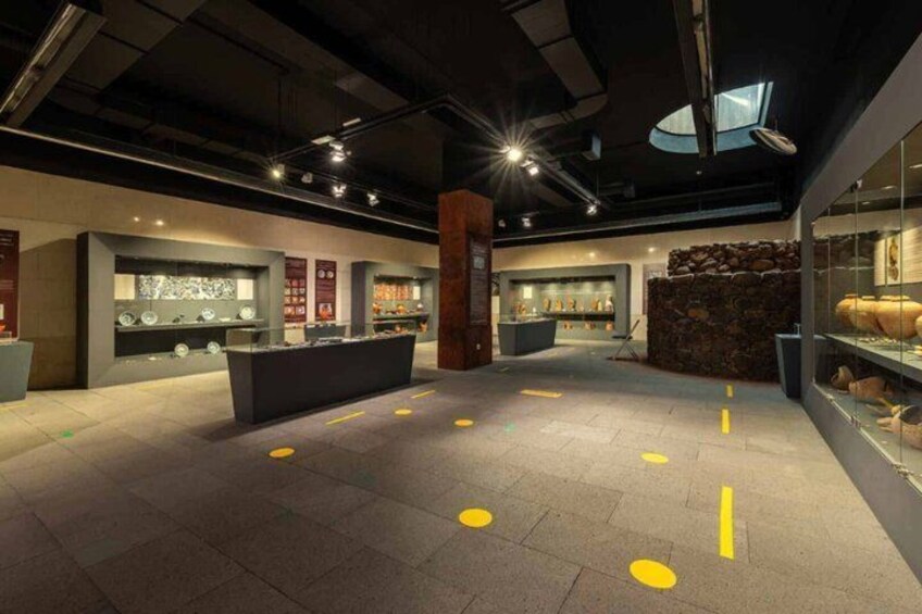 An indoor museum with exhibits, a central display, and a skylight. 4