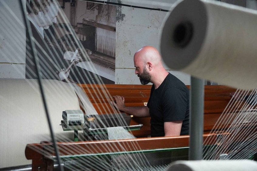 A person operating machinery with a large roll of material. 5