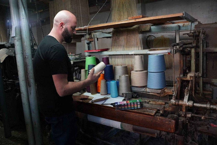 A person working with spools of thread in a workshop. 4