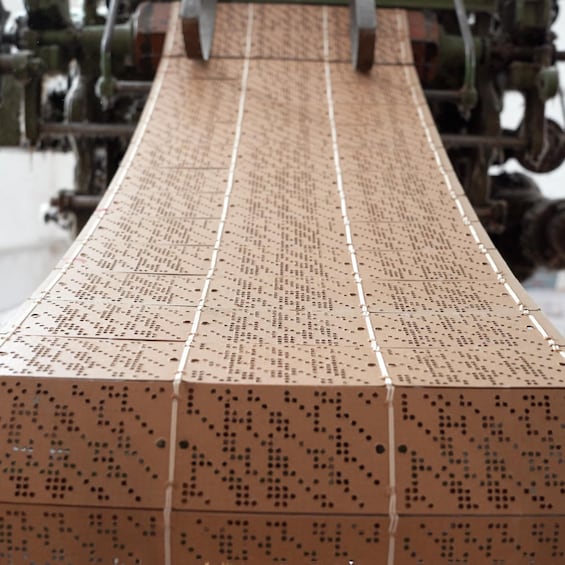 A long, flat surface with a grid of small holes, likely a tactile map or diagram. 3