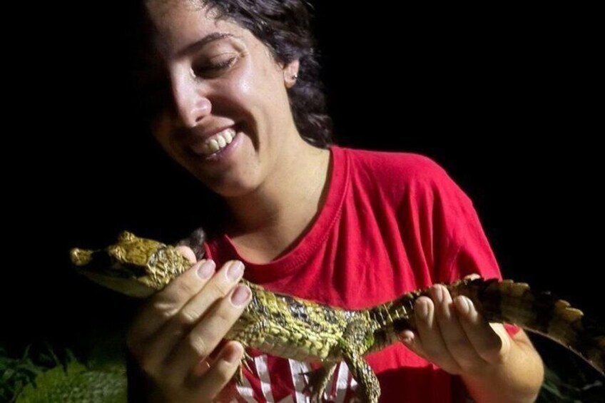 A person holding a large lizard. 2