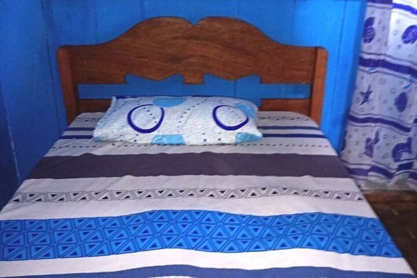 A bed with a patterned bedspread and a pillow with a face design. 4