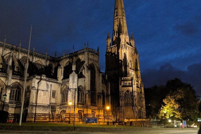 Een gotische kathedraal met een hoge toren, verlicht door straatverlichting. 5