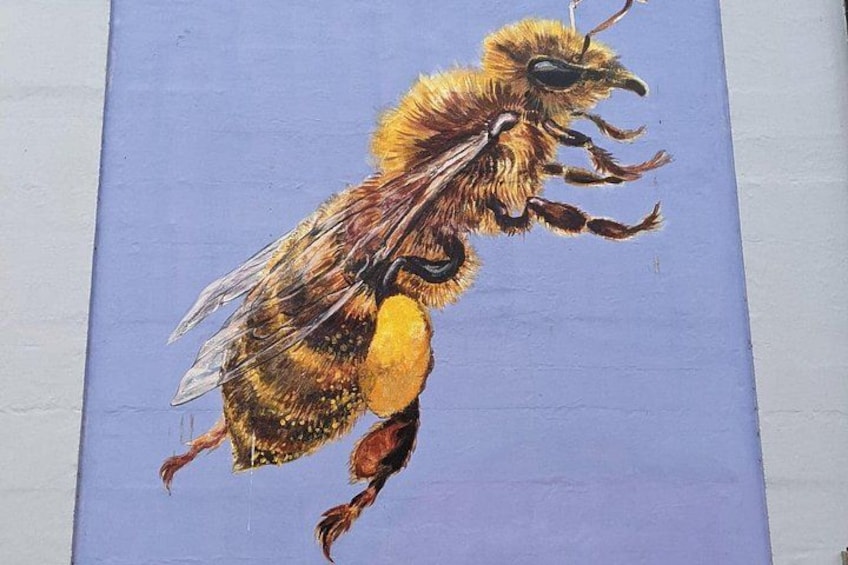 A detailed painting of a bee on a blue background. 1