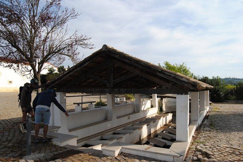 A stone structure with a roof, possibly a historical building or monument, with steps leading up to it. 4