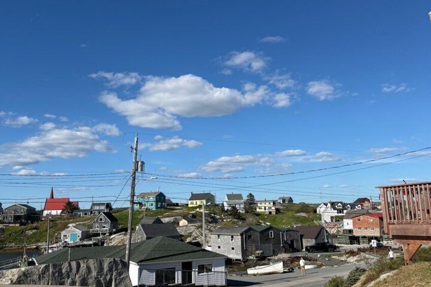 A coastal village with houses, a dock, and a clear blue sky. 3