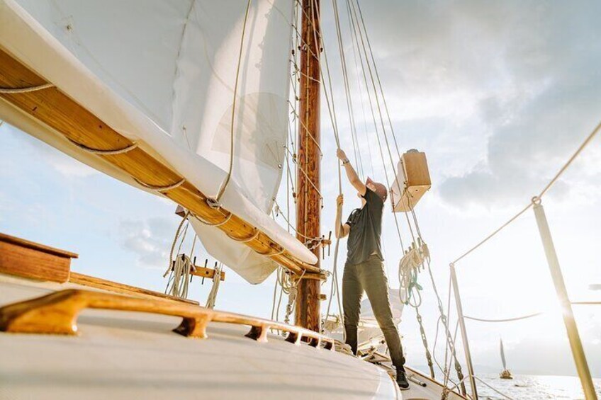 A person on a sailboat, ropes, and wooden deck. 1