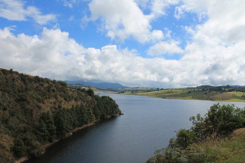 A lake surrounded by hills, a clear sky, and distant mountains. 2