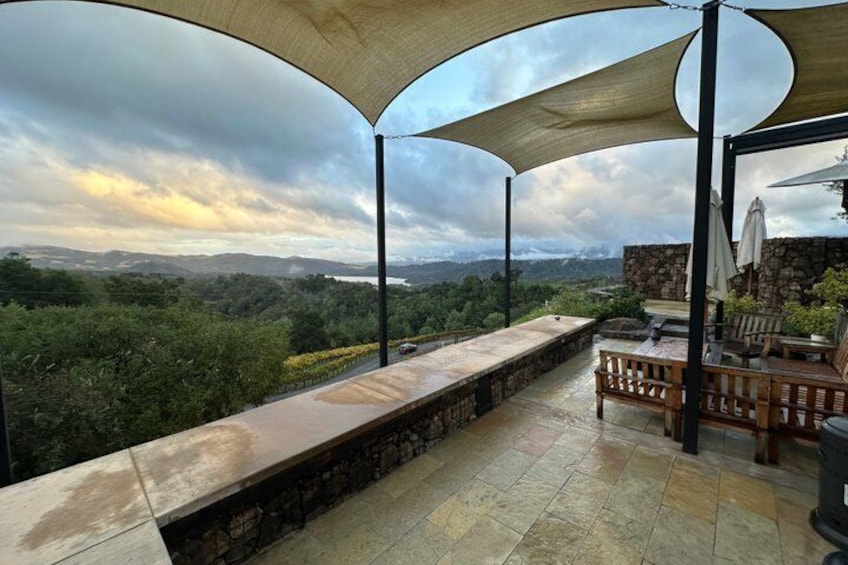 A covered outdoor seating area with a view of a mountainous landscape. 1