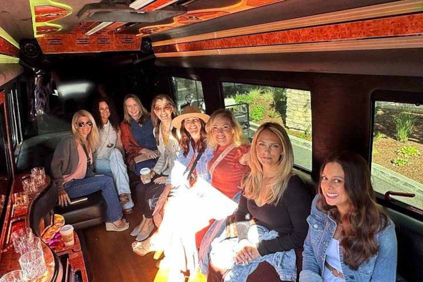 A group of people seated inside a vehicle with a table in front of them. 4