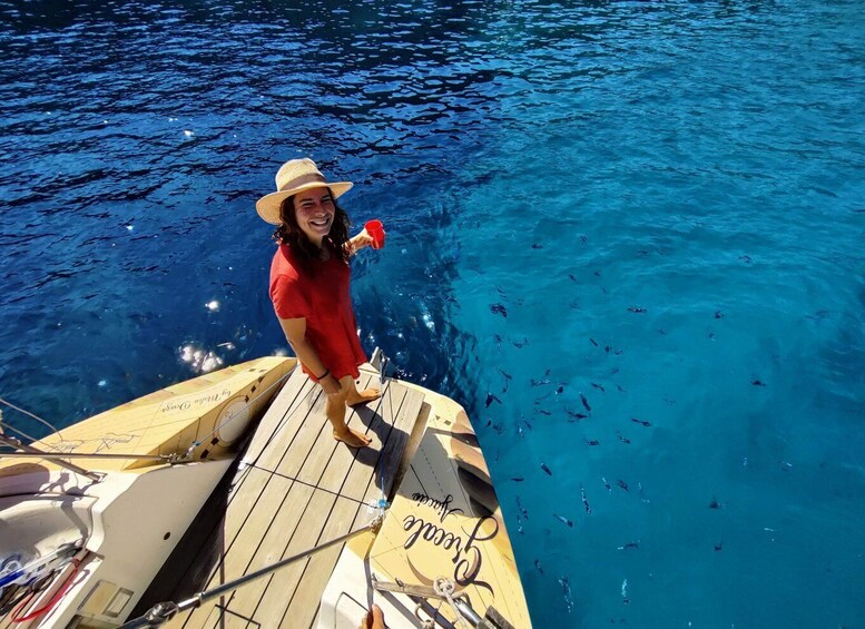 A person on a boat with a hat, holding a red cup, and the boat has the word 'room' on it. 2