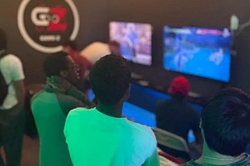 People playing video games in a room with multiple screens. 4