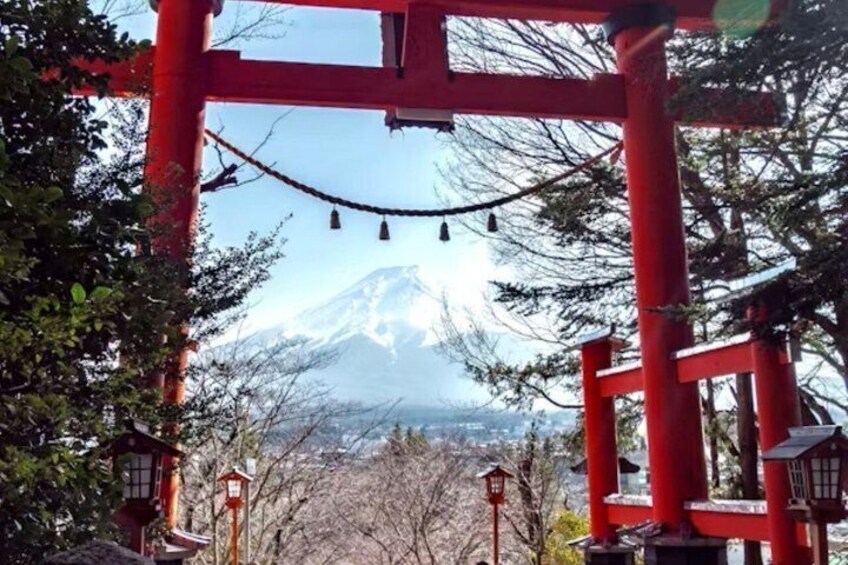 A red torii gate with a view of a snow-capped mountain in the background. 4
