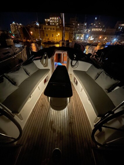A boat deck at night with a view of a cityscape in the background. 2