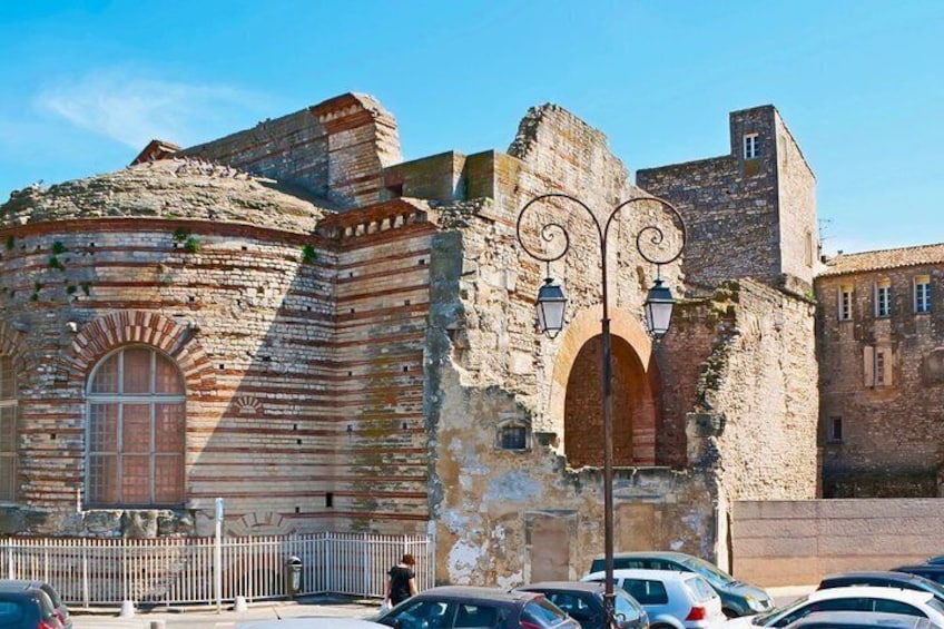 A historic stone building with arched windows and a metal lamp post. 5