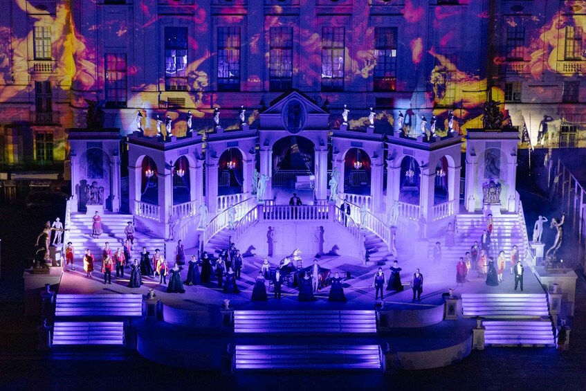 A grand building with a central staircase and statues. 5