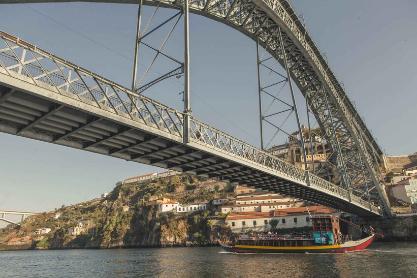 A bridge spanning over a river with a boat in the foreground and buildings on the opposite bank. 3