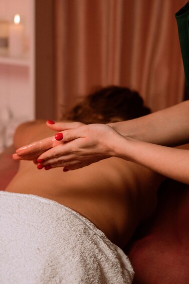 A person receiving a massage with hands on their back. 5