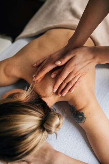 A person receiving a massage with hands on their back. 2