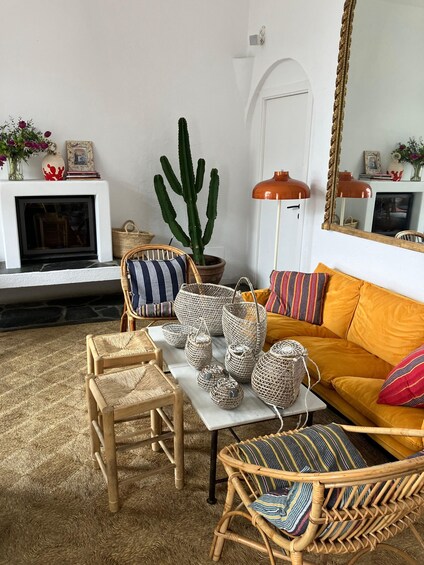 A cozy living room with wicker furniture, a cactus plant, and a yellow sofa. 3