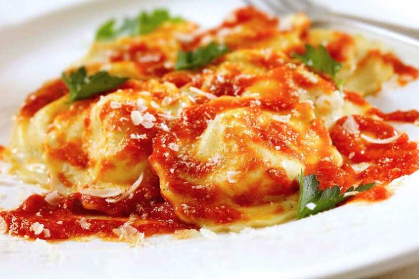 Ravioli in tomato sauce garnished with cheese and parsley. 3
