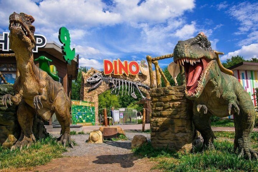 A dinosaur-themed entrance with a sign reading 'DINO' and life-sized dinosaur statues. 5