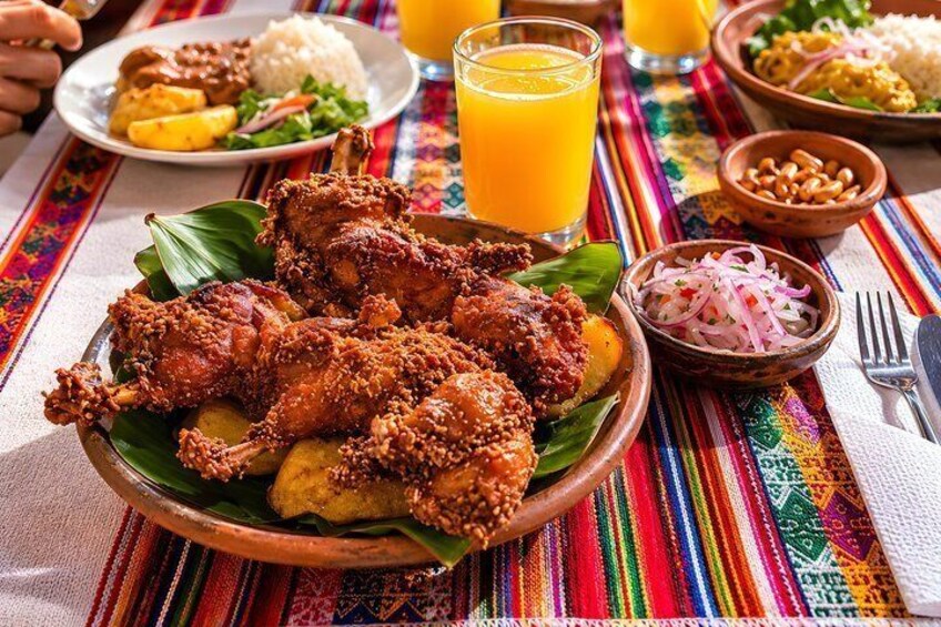 A meal with fried chicken, a banana, and a glass of orange juice on a colorful tablecloth. 3