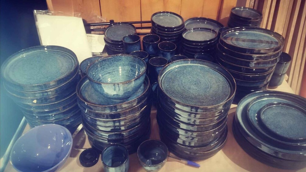 A collection of blue glassware, including bowls and cups, stacked on shelves. 2