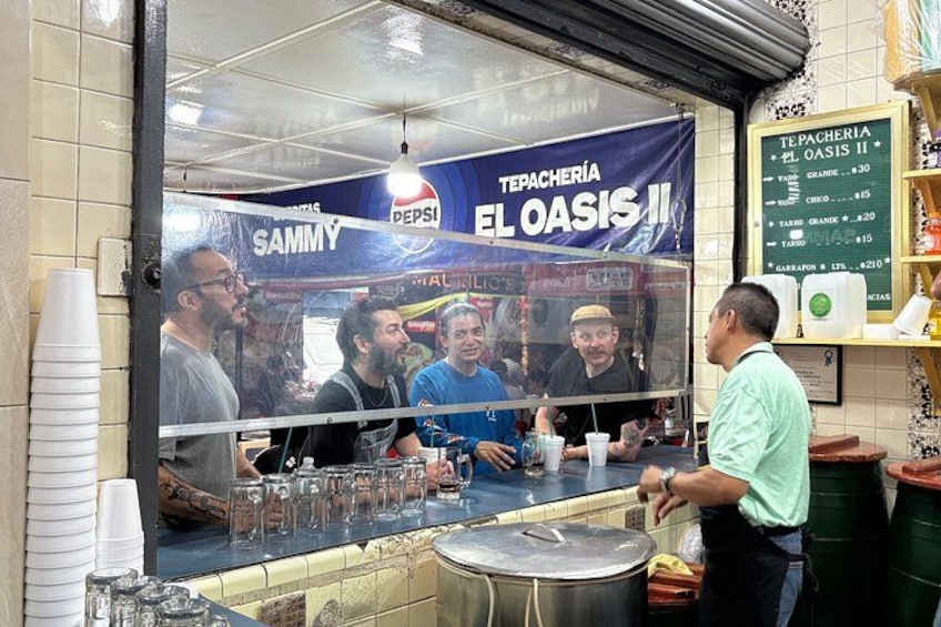 A food stall with a Pepsi advertisement, a menu board, and a counter with glasses and a pot. 4