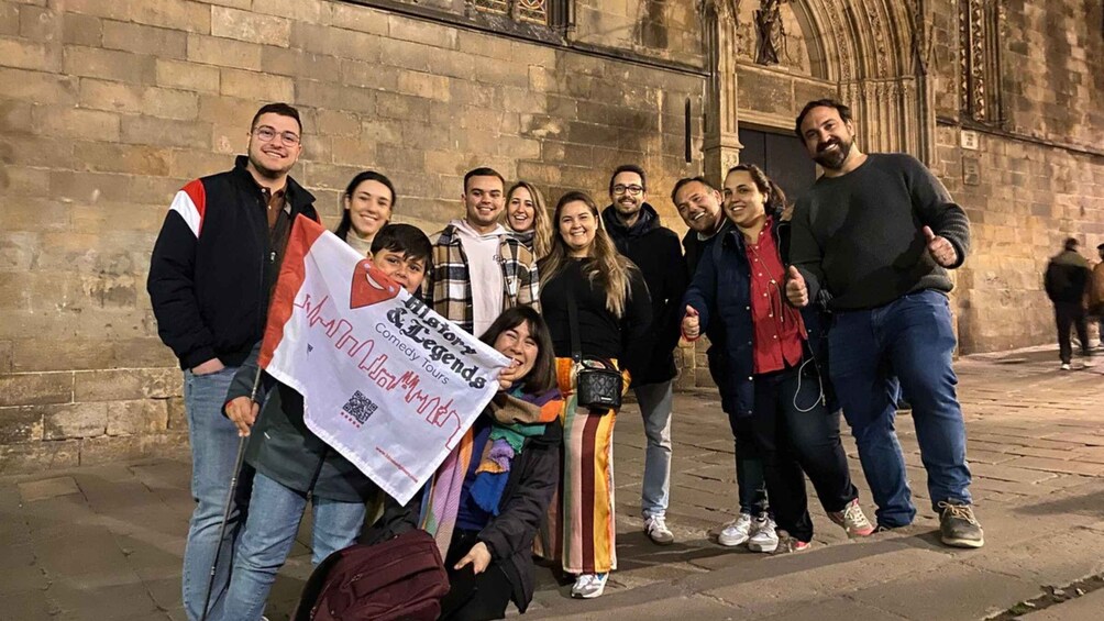 A group of people standing in front of a historic building with Gothic architecture. 4