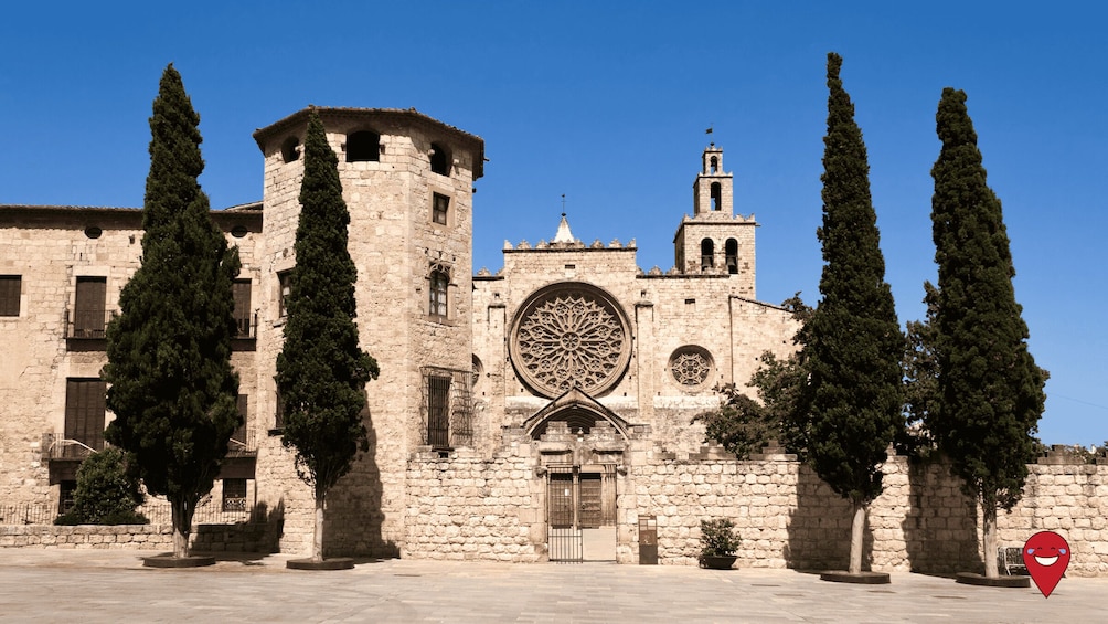 A historic stone building with a large circular window and a bell tower. 1