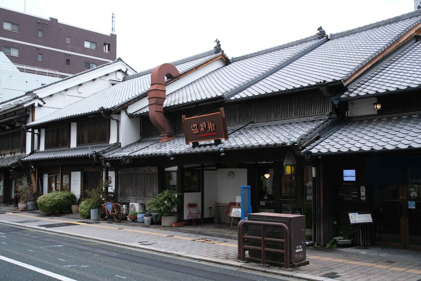 A traditional Japanese building with a tiled roof and a signboard. 1