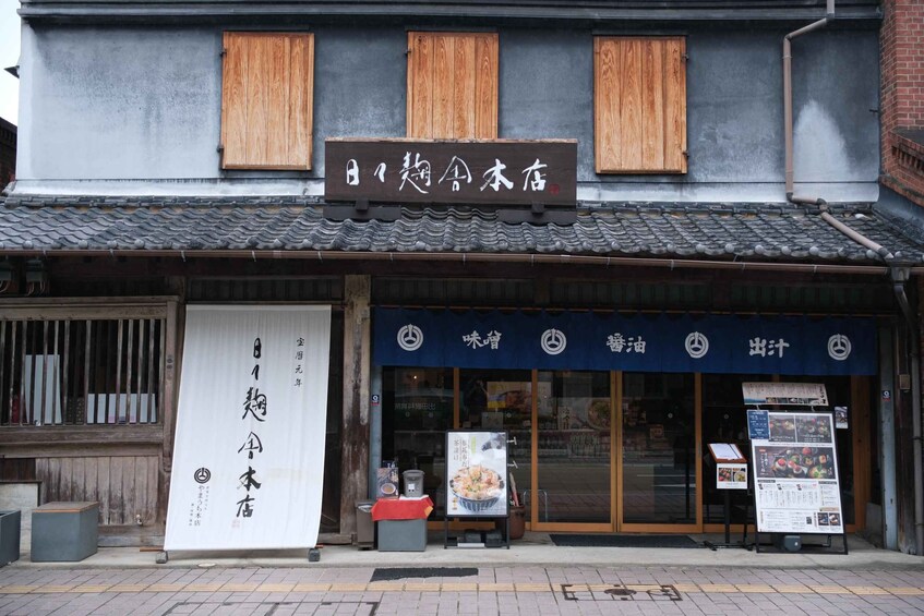 A traditional Japanese building with a signboard and a menu display outside. 5