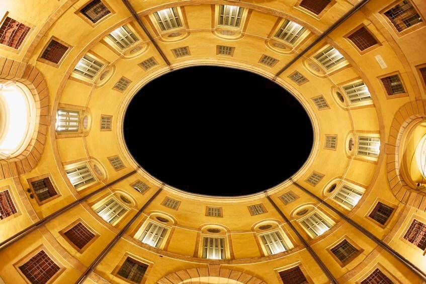 A circular architectural structure with multiple windows and balconies. 2