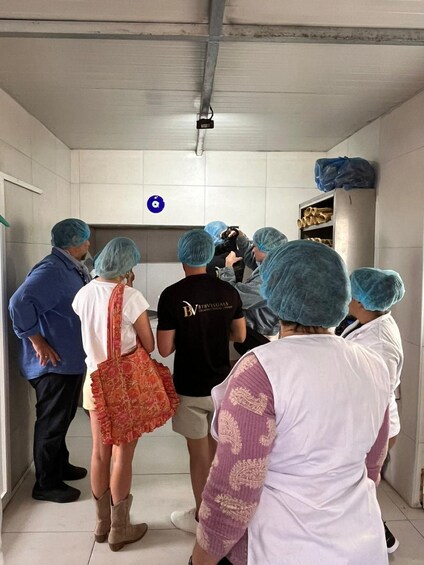 A group of people in a hallway, some wearing hairnets and others in casual clothing. 3