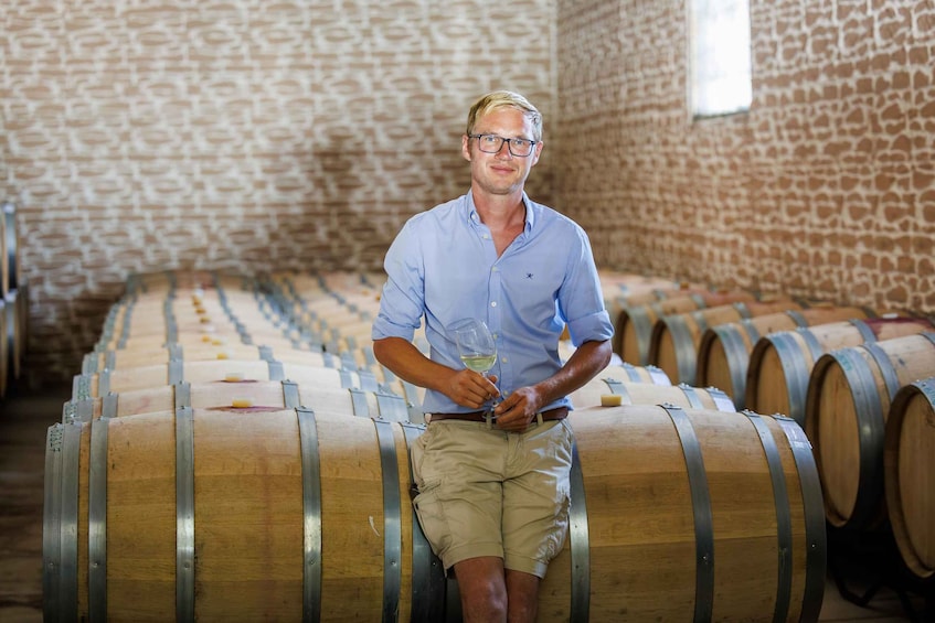 A man in a winery with wooden barrels. 2