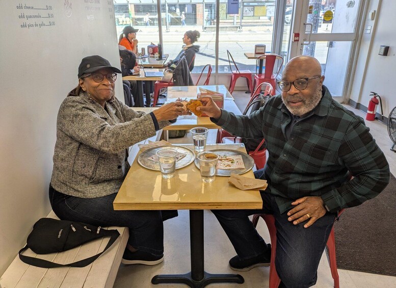 Two people sitting at a table with a menu, eating and drinking. 5