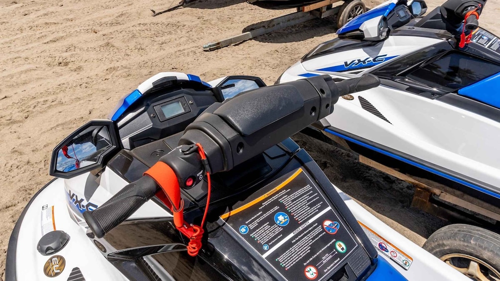 A close-up of a jet ski's control panel with a warning label. 1