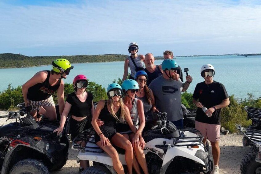 A group of people on ATVs by a lake. 2