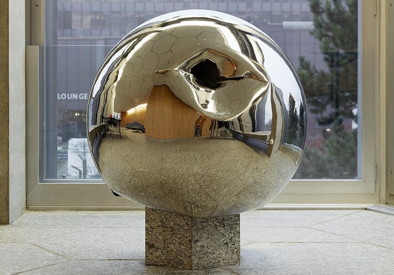 A reflective metallic sculpture on a pedestal. 5