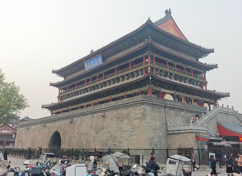 A traditional multi-tiered building with ornate architecture, a large arched entrance, and a red roof. 3