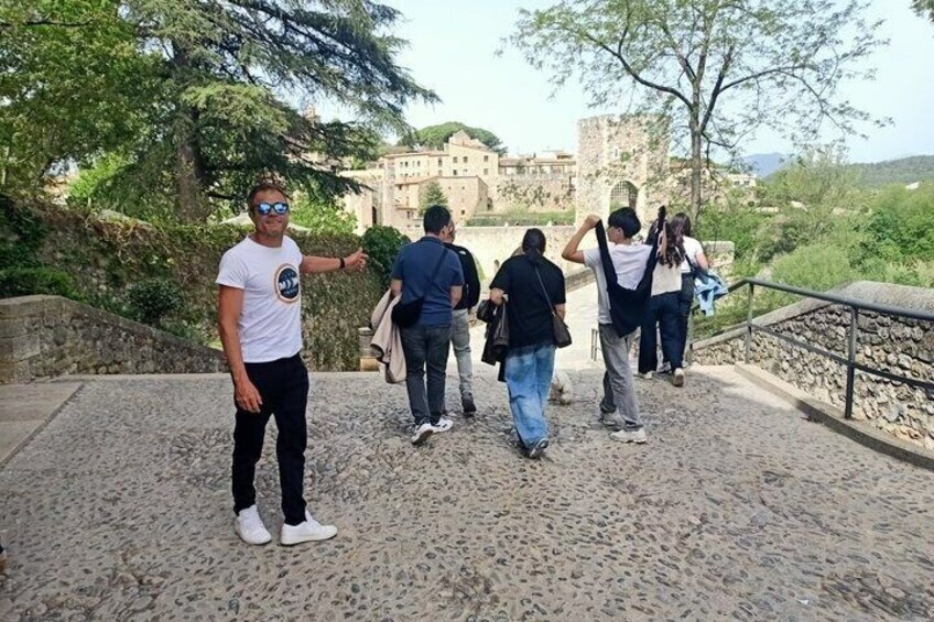 A group of people walking on a cobblestone path with a historic building in the background. 4