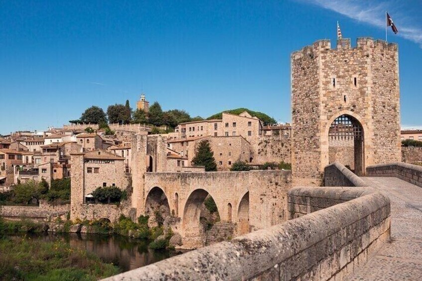 A historic stone bridge, a castle tower, and a town with buildings. 3